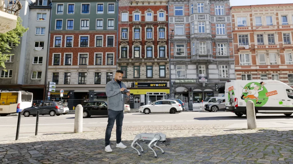 Robo4Rent robot dog and Manzor Aluko outside the residential buildings on Holstenstraße in Hamburg.